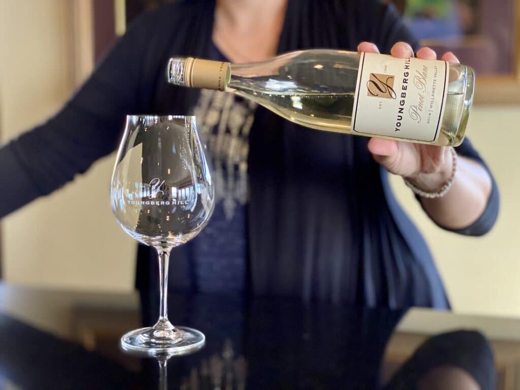 10 Best Wineries in the Willamette Valley, photo of a woman pouring wine at Youngberg Hill
